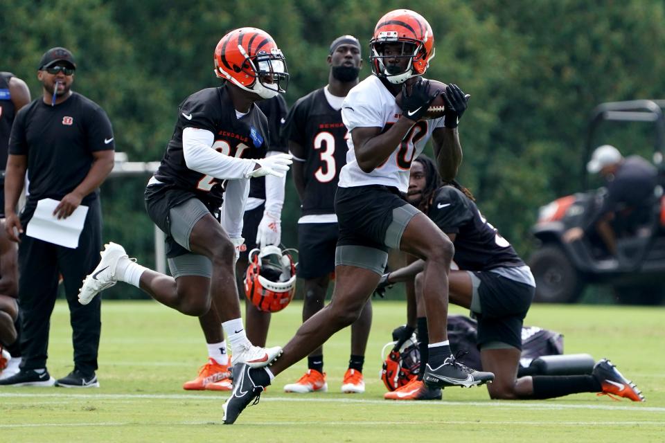 Cincinnati Bengals cornerback Mike Hilton (21) steps on the heel of Cincinnati Bengals wide receiver Mike Thomas (80) as he completes a catch during Cincinnati Bengals training camp practice, Friday, July 29, 2022, at the practice fields next to Paul Brown Stadium in Cincinnati. 