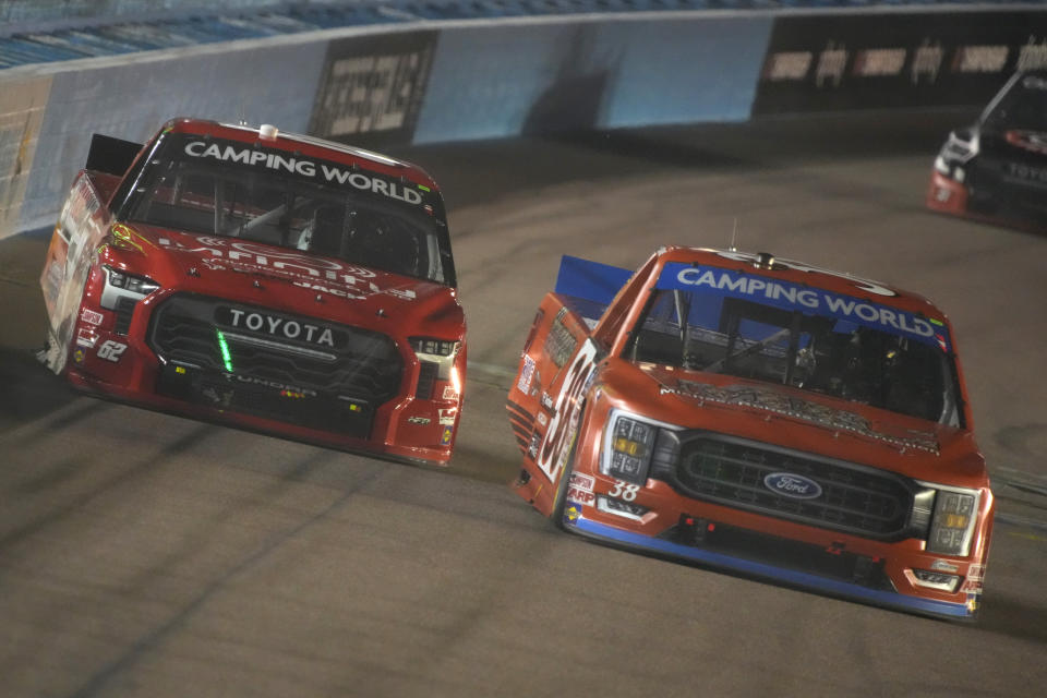 Zane Smith (38) passes Layne Riggs during a NASCAR Truck Series auto race Friday, Nov. 4, 2022, in Avondale, Ariz. (AP Photo/Rick Scuteri)