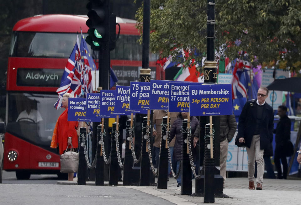 Anti Brexit protestors show their posters in front of parliament in London, Wednesday, Oct. 23, 2019. Britain's government is waiting for the EU's response to its request for an extension to the Brexit deadline. (AP Photo/Frank Augstein)