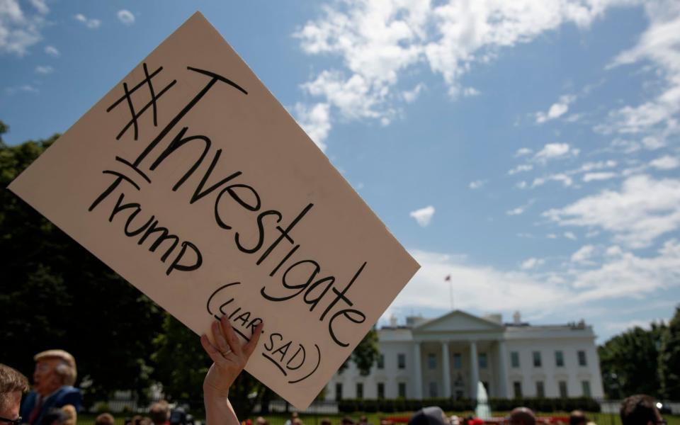 Demonstrators gather outside the White House after Comey's sacking - Credit: AP