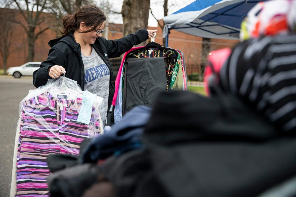 Jacki Rodriguez, director of the office of first-generation student success, holds up clothes that have been donated for the career closet donation drive at the University of Memphis on Friday, March 8, 2024. The donation drive serves to give first-generation students access to professional clothing.