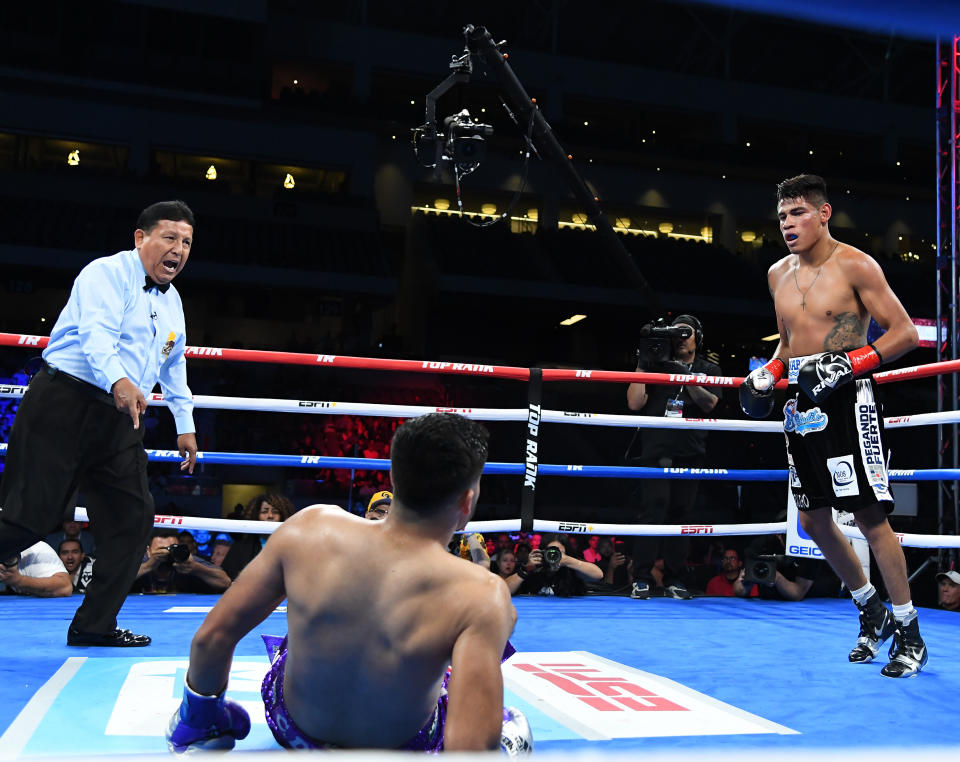 LOS ANGELES, CA - AUGUST 17: Referee Raul Caiz Sr. sends Emanuel Navarrete (black shorts) to a neutral corner after he knocked down Francisco De Vaca (purple shorts) in their WBO World Title fight at Banc of California Stadium on August 17, 2019 in Los Angeles, California.  Navarrete won by knockout.  (Photo by Jayne Kamin-Oncea/Getty Images)