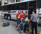 Volunteers help a wheelchair bound man onto a charter bus at Savannah's Civic Center as residents evacuate from Hurricane Dorian, Tuesday, Sept. 3, 2019, in Savannah, Ga. (Steve Bisson/Savannah Morning News via AP)