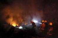 Firefighters work to put out a fire in Valparaiso city, northwest of Santiago, April 13, 2014. REUTERS/Cristobal Saavedra