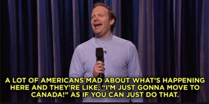 A comedian on stage performs a stand-up act. The text in the image reads: "A lot of Americans mad about what’s happening here and they’re like, 'I’m just gonna move to Canada!' as if you can just do that."