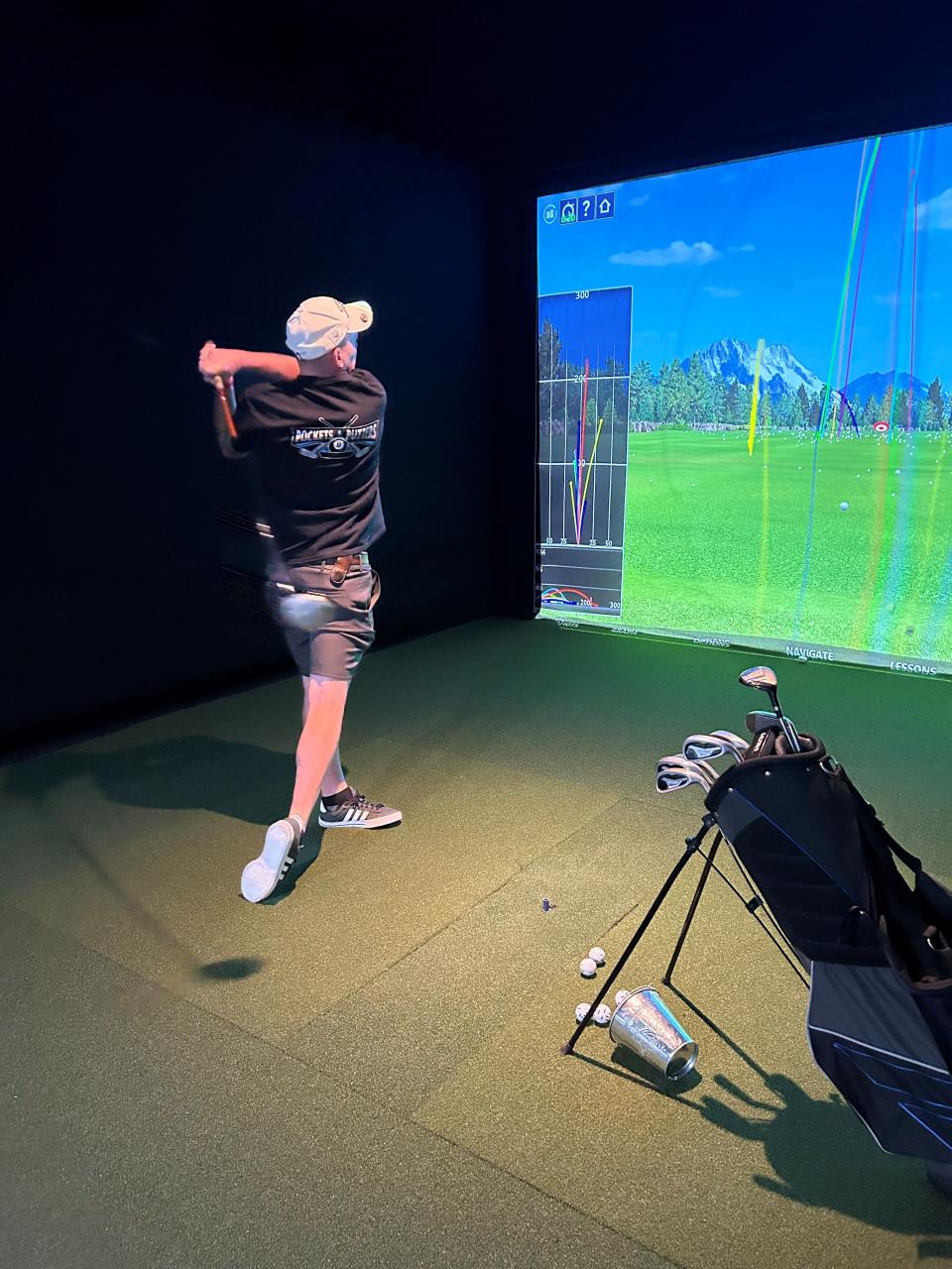 Sonny Barrett, owner of Pockets & Putters in Rockledge, demonstrates how the golf simulator works.