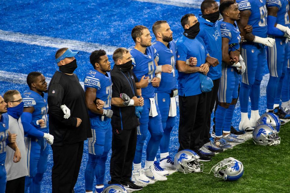 Lions players include quarterback Matthew Stafford, center, lock arms with each other as they watch a pregame presentation at the end zone before the season opener against the Chicago Bears on Sunday, Sept. 13, 2020.