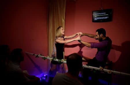 Actors Anthony Rotsa (R) and Veronica Polo perform in front of spectators at Microteatro Por Dinero (Microtheatre for money) in central Madrid, Spain September 2, 2016. Picture taken September 2, 2016. REUTERS/Andrea Comas