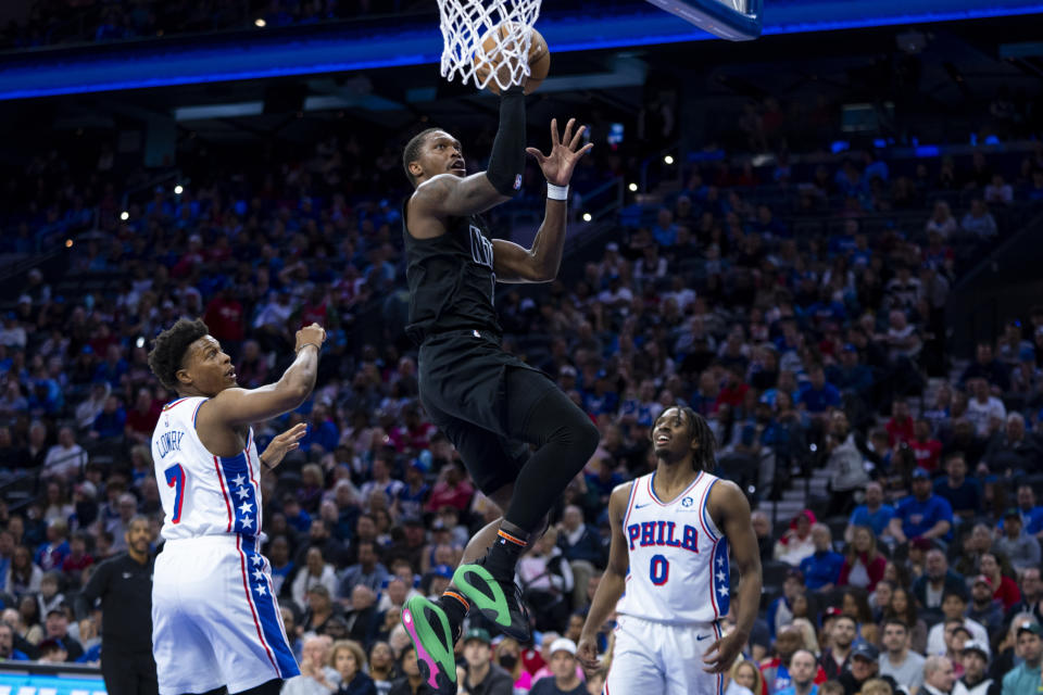 Brooklyn Nets' Lonnie Walker IV, center, goes up to shoot as Philadelphia 76ers' Kyle Lowry, left, and Tyrese Maxey, right, watch during the first half of an NBA basketball game, Sunday, April 14, 2024, in Philadelphia. (AP Photo/Chris Szagola)