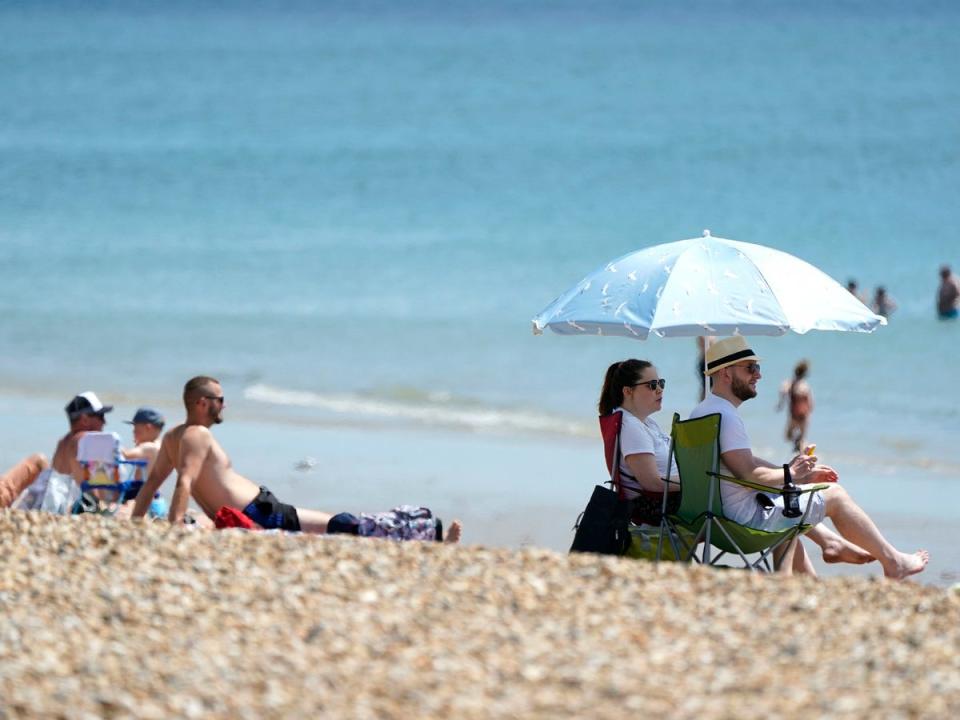 People enjoying the warm weather on Southsea Beach in Hampshire on Saturday (Andrew Matthews/PA)