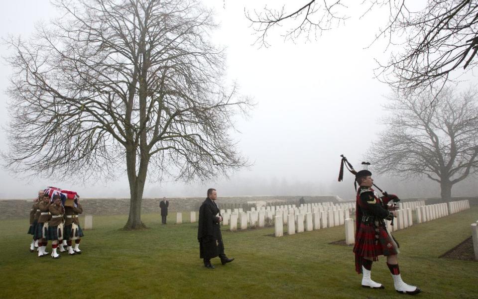 A Scottish piper leads a procession of pallbearers carrying the casket of British World War One soldier William McAleer during a reburial service at the Loos British World War One cemetery in Loos-en-Gohelle, France on Friday, March 14, 2014. Private William McAleer, of the 7th Battalion, Royal Scots Fusiliers, was killed in action on Sept. 26, 1915 during the Battle of Loos. His body was found and identified in 2010 during routine construction in the area and is being reburied with full military honors along with 19 unknown soldiers. (AP Photo/Virginia Mayo)