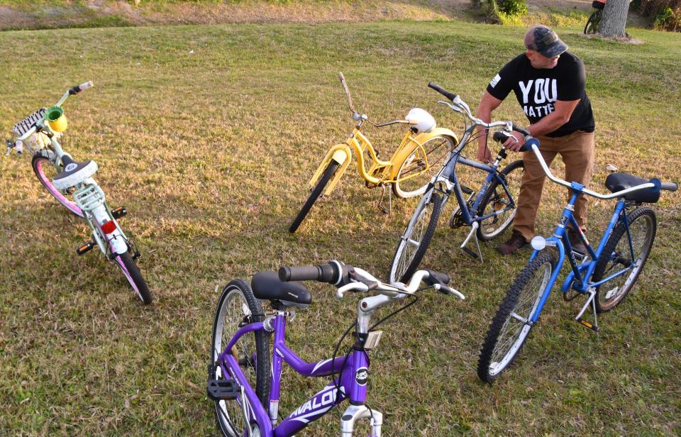 Jon Moist, volunteer with the Under the Bridge ministry, brings bicycles to a Jan. 23 gathering at Sand Point Park in Titusville, where meals, blankets and services like haircuts are offered by the ministry on Monday nights..