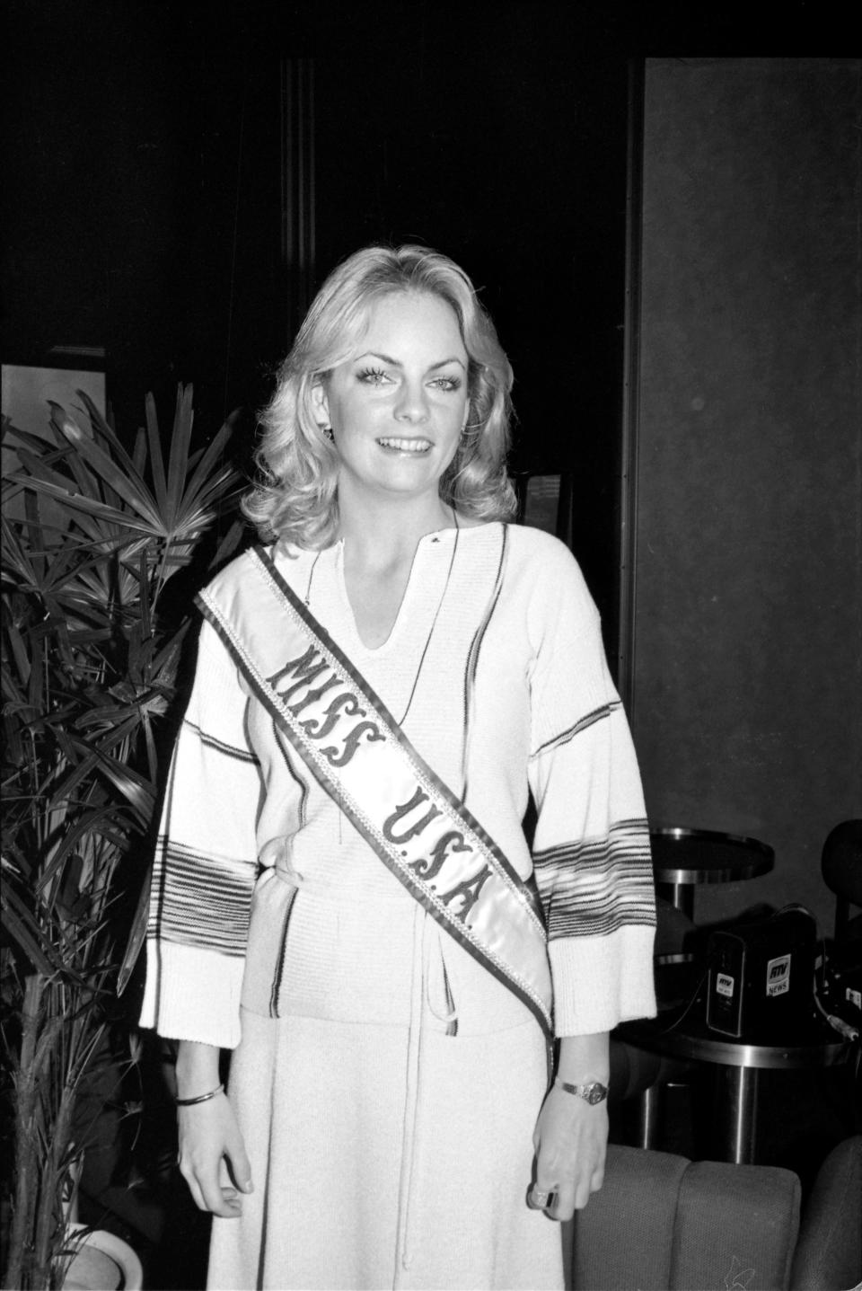 Miss USA 1977 Kimberly Tomes smiles wearing her sash.