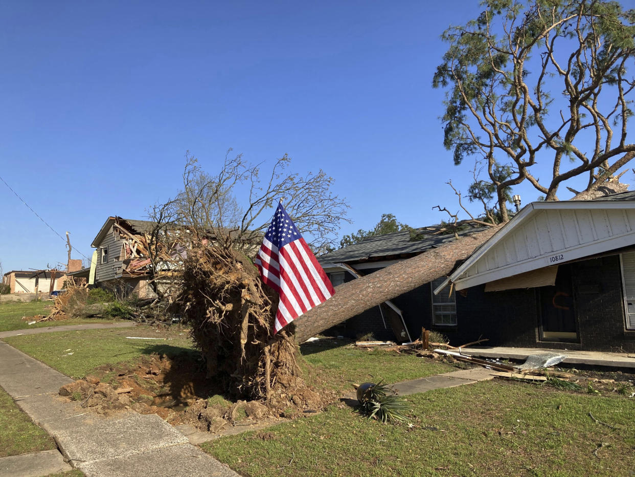 A fallen tree damages a house after a storm in Little Rock, Ark., on Saturday, April 1, 2023. Unrelenting tornadoes that tore through parts of the South and Midwest that shredded homes and shopping centers. (AP Photo/Andrew DeMillo)