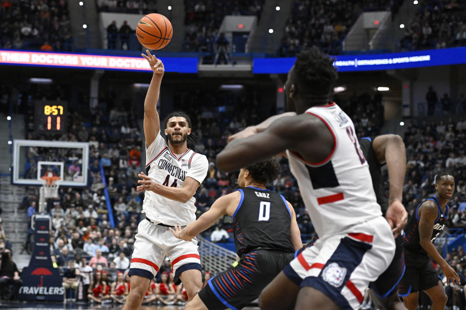 UConn's Andre Jackson Jr. (44) passes the ball to teammate UConn's Adama Sanogo in the first half of an NCAA college basketball game against DePaul, Wednesday, March 1, 2023, in Hartford, Conn. (AP Photo/Jessica Hill)