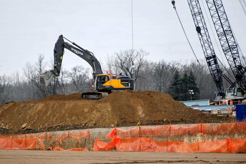 An excavator moves dirt at the Ultium Cells battery cell manufacturing facility construction site on Monday, Dec. 12, 2022, in Delta Township.