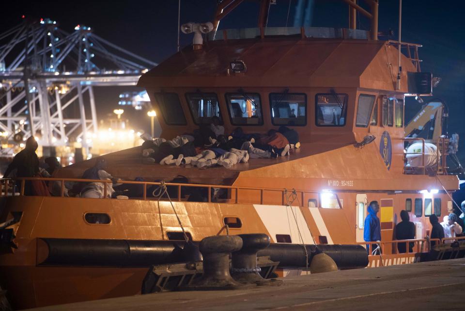 In this photo taken late Wednesday, July 25, 2018, migrants prepare to spend the night onboard a Spanish Maritime Rescue Service boat docked at the port of Algeciras, southern Spain, after being rescued in the Strait of Gibraltar. Around 800 migrants stormed border fences separating Spain's North African enclave of Ceuta from Morocco to get into Europe, police said Thursday. (AP Photo/Marcos Moreno)