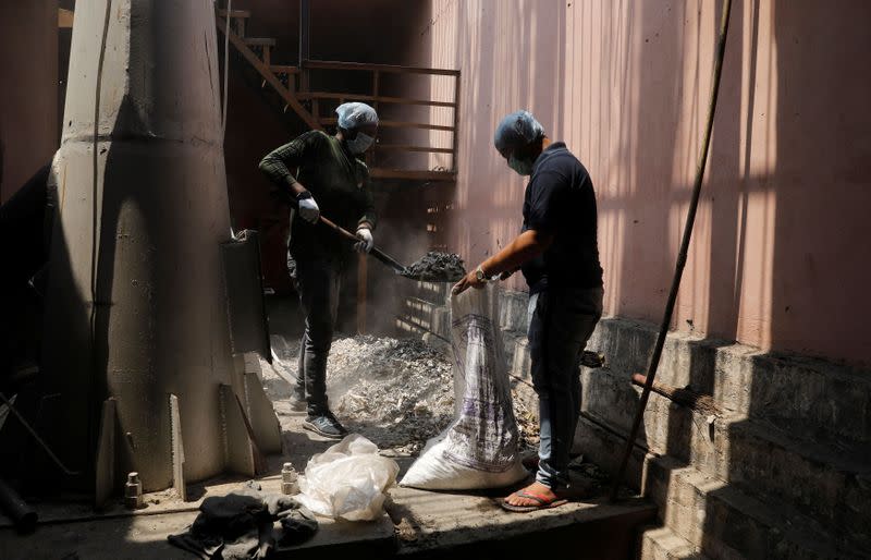 Kashyap and Sharma collect unclaimed ashes of the victims who died from the coronavirus disease (COVID-19), at a crematorium in New Delhi