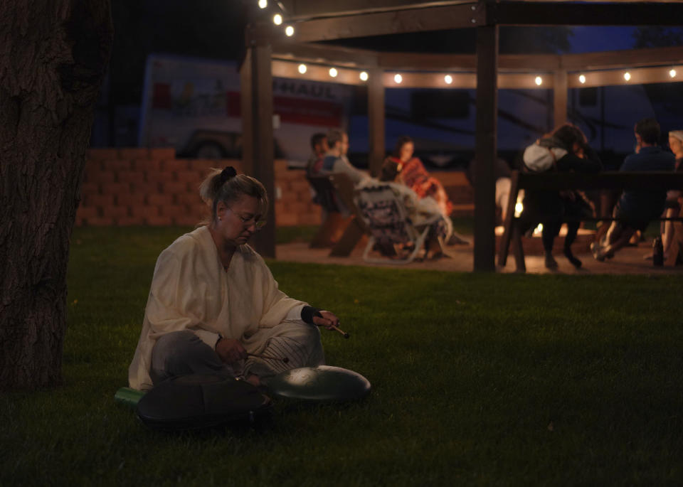 Talia Gross, a retreat participant, plays a sound bowl while waiting for the ayahuasca ceremony to begin at a Hummingbird Church retreat in Hildale, Utah, on Friday, Oct. 14, 2022. (AP Photo/Jessie Wardarski)