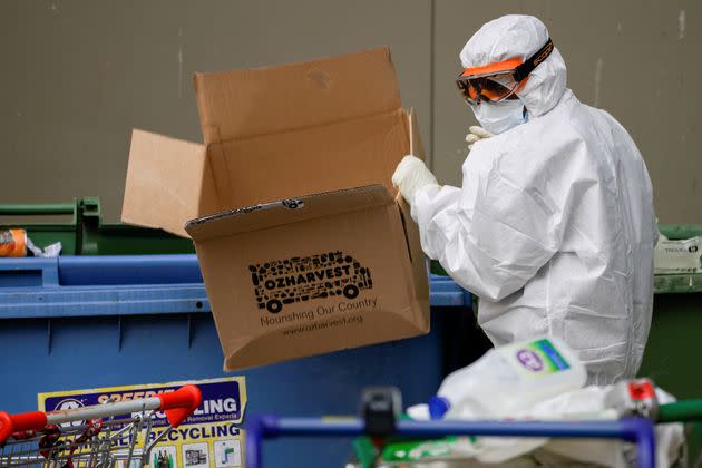 A worker dressed in personal protective equipment disposes of rubbish outside a public housing tower, reopened the previous night after being locked down in response to an outbreak of the coronavirus disease (COVID-19), in Melbourne, Australia, July 10, 2020. REUTERS/Sandra Sanders