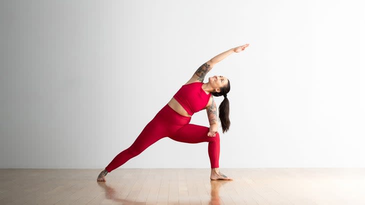 Woman in Extended Side Angle Pose variation with arm on thigh
