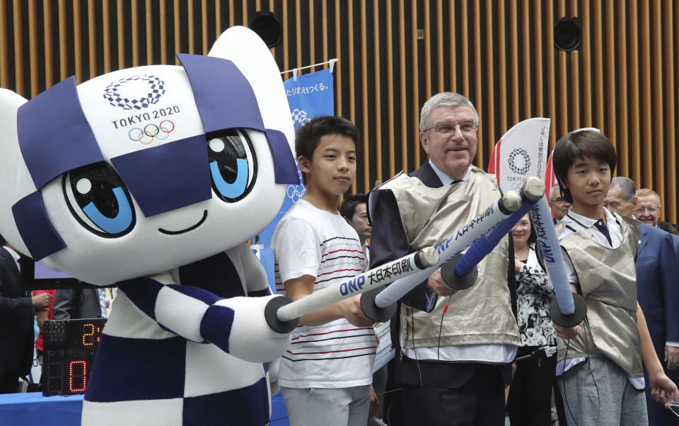 IOC President Thomas Bach poses for a photo with Japanese junior high school student Yui Hashimoto, right, and Yuto Tojima, second from left, and Miraitowa, mascot of Tokyo 2020 during a Olympic Games Tokyo 2020 One year to Go ceremony event in Tokyo, Wednesday, July 24, 2019. Bach is a former Olympic fencer and won a team gold medal at the 1976 Montreal Games. (AP Photo/Koji Sasahara, Pool)