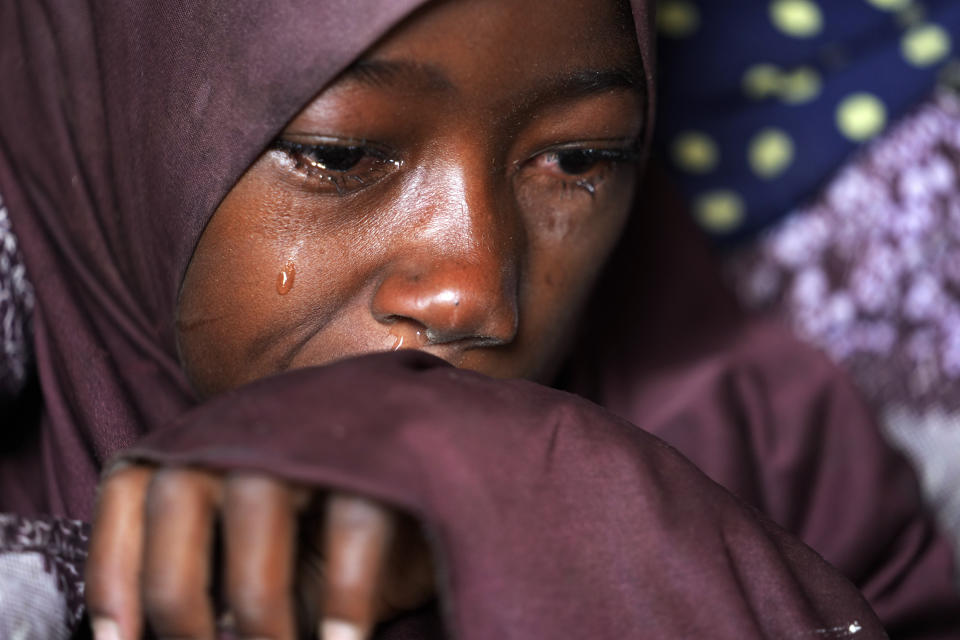 Husseina Ali, 9, daughter of Aisha Ali, cries inside hut where she found refuge from the floods in Darayami, northeastern Nigeria, Wednesday Oct. 26, 2022. When floodwaters reached her hut made of woven straw mats and raffia palms, Aisha packed up what belongings she could and set off on foot with her eight youngest children. "While the flood was trying to destroy things, we were trying to save ourselves," she said. Four of her children perished. (AP Photo/Sunday Alamba)