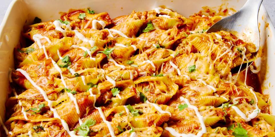 stuffed pasta shells with chicken, cheese, enchilada sauce, and a drizzle of sour cream