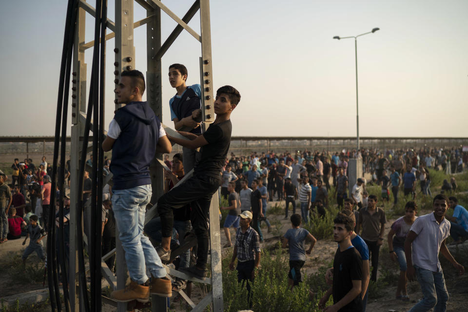 Palestinian gather during a protest at the entrance of Erez border crossing between Gaza and Israel, in the northern Gaza Strip, Tuesday, Sept. 4, 2018. The Health Ministry in Gaza says several Palestinians were wounded by Israeli fire as they protested near the territory's main personnel crossing with Israel. (AP Photo/Felipe Dana)