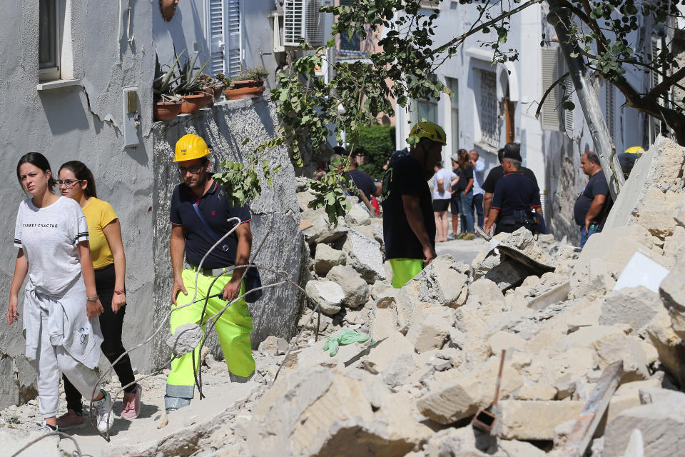 <p>Rescuers teams walk near a damaged building in one of the more heavily damaged areas on Aug. 22, 2017 in Casamicciola Terme, Italy. (Photo: Marco Cantile/NurPhoto via Getty Images) </p>