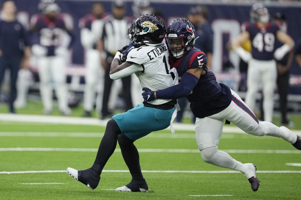 Jacksonville Jaguars running back Travis Etienne Jr. (1) is hit by Houston Texans safety Jalen Pitre (5) on a run during the first half of an NFL football game in Houston, Sunday, Jan. 1, 2023. (AP Photo/David J. Phillip)