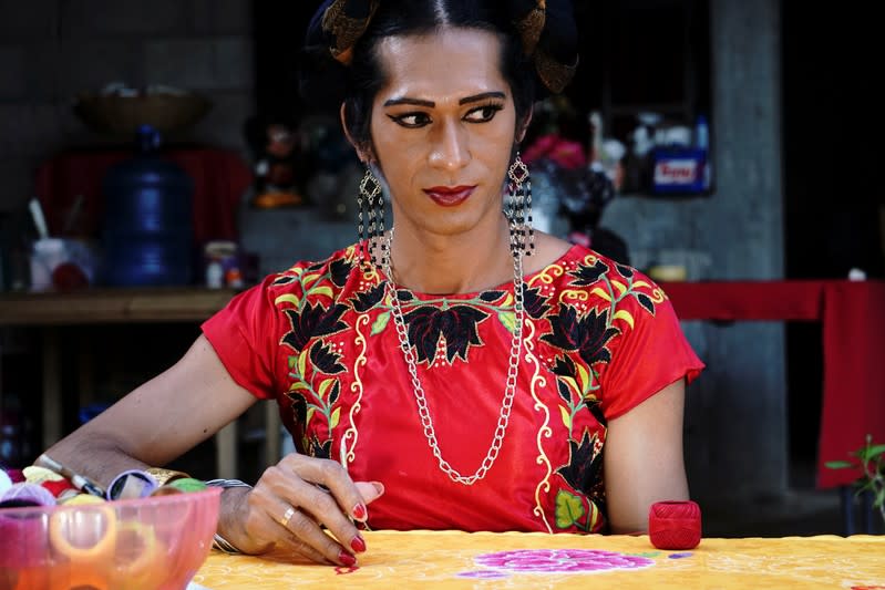 Estrella Vasquez, a muxe woman who features on the cover of Vogue magazine, poses for a photo while painting a Huipil at her house in Juchitan