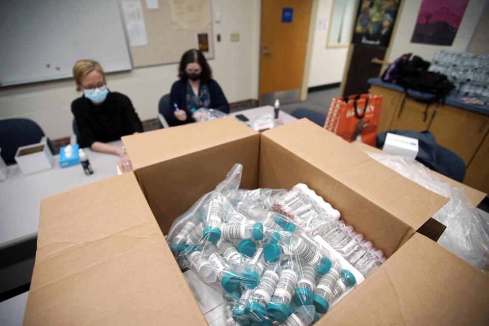 FILE - In this Oct. 25, 2021, file photo, registered Nurse Carisa Vincent, and Hope Rose Kelly prepare pool tests for COVID-19 behind a mountain of supplies at Reid Middle School in Pittsfield, Mass. Tumbling COVID-19 case counts have some schools around the U.S. considering relaxing their mask rules, but deaths nationally have been ticking up over the past few weeks, some rural hospitals are showing signs of strain, and cold weather is setting in. (Ben Garver/The Berkshire Eagle via AP, File)