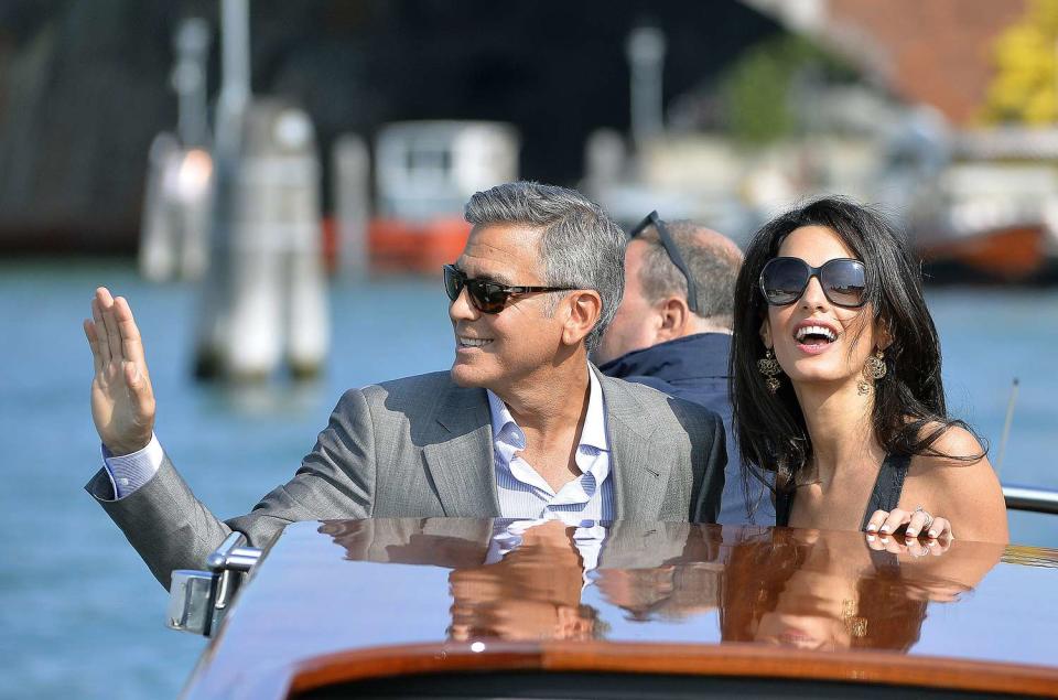 US actor George Clooney ( L) and his Lebanon-born British fiancee Amal Alamuddin take a taxiboat upon their arrival in Venice on September 26, 2014, on the eve of their wedding