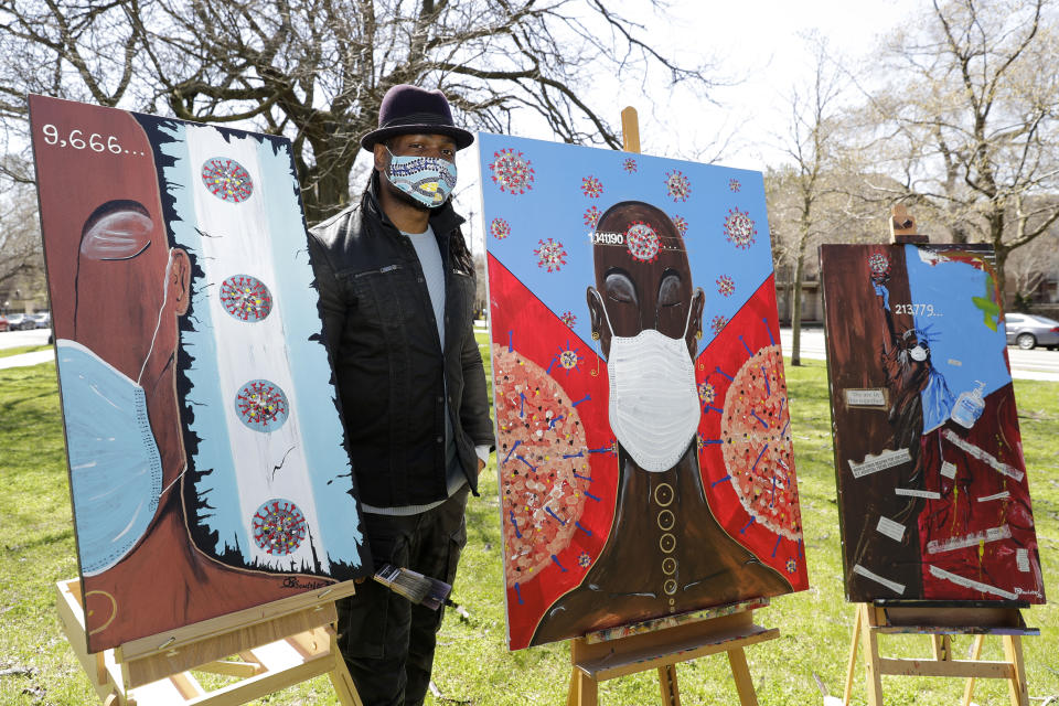 In this Tuesday, April 21, 2020 photo, Obi Uwakwe poses with his painting in Chicago. Uwakwe is an artist/photographer and submitted his art work to the the Illinois State Museum, which is documenting what daily life is like for Illinois families during the coronavirus pandemic. (AP Photo/Nam Y. Huh)