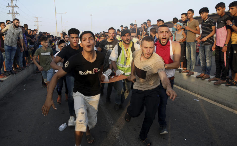 Protesters evacuate a wounded youth during a protest at the entrance of Erez border crossing between Gaza and Israel, in the northern Gaza Strip, Tuesday, Sept. 4, 2018. The Health Ministry in Gaza says several Palestinians were wounded by Israeli fire as they protested near the territory's main personnel crossing with Israel. (AP Photo/Adel Hana)