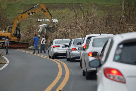 Workers uses a backhoe to remove debris from the street after the area was hit by Hurricane Maria in Yabucoa, Puerto Rico September 22, 2017. REUTERS/Carlos Garcia Rawlins