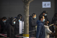 People wearing face masks to protect against the spread of the coronavirus prepare to enter a site for mass COVID-19 testing in a central district of Beijing, Friday, Jan. 22, 2021. Beijing has ordered fresh rounds of coronavirus testing for about 2 million people in the downtown area following new cases in the Chinese capital. (AP Photo/Mark Schiefelbein)