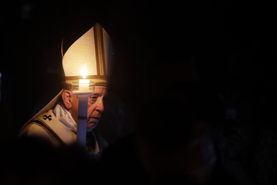 Pope Francis holds a candle as he presides over a solemn Easter vigil ceremony in St. Peter's Basilica at the Vatican, Saturday, April 21, 2019. (AP Photo/Gregorio Borgia)