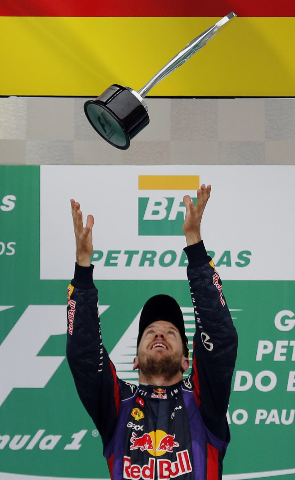 Sebastian Vettel of Germany throws the trophy in the air as he celebrates on the podium after the Brazilian F1 Grand Prix at the Interlagos circuit in Sao Paulo