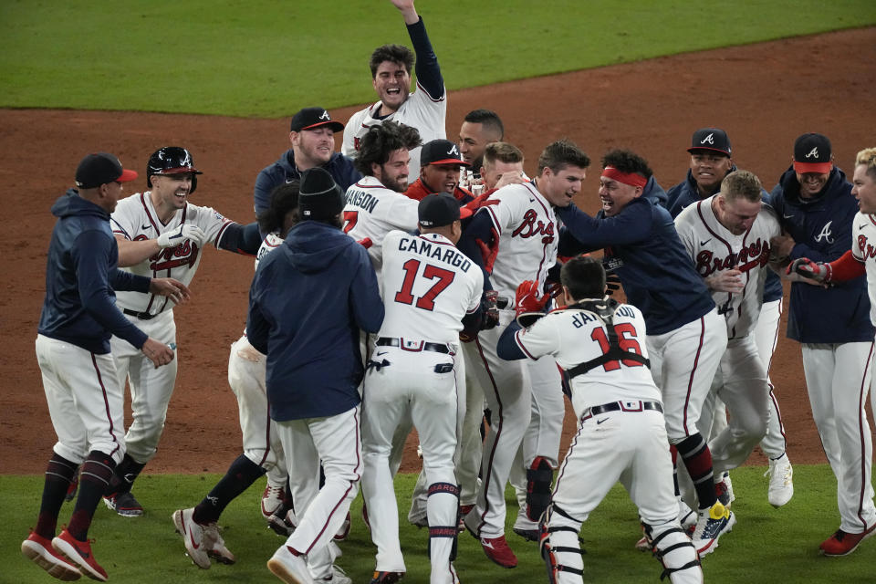 Atlanta Braves' Austin Riley, center, is congratulated by teammates after hitting the game winning RBI single to score Atlanta Braves' Ozzie Albies in the ninth inning in Game 1 of baseball's National League Championship Series against the Los Angeles Dodgers Saturday, Oct. 16, 2021, in Atlanta. The Braves defeated the Dodgers 3-2 to take game 1. (AP Photo/John Bazemore)