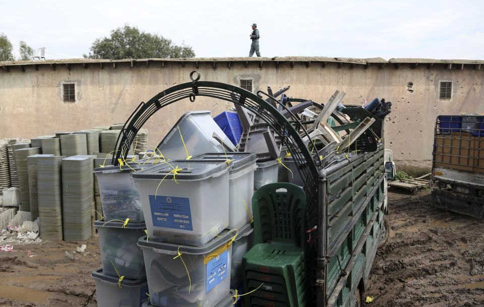 An Afghan police officer provides security as a truck carrying ballot boxes arrives at the election commission office after votes in Jalalabad, east of Kabul, Afghanistan, Sunday, April 6, 2014. Across Afghanistan, voters turned out in droves Saturday to cast ballots in a crucial presidential election. The vote will decide who will replace President Hamid Karzai, who is barred constitutionally from seeking a third term. Partial results are expected as soon as Sunday. (AP Photo/Rahmat Gul)