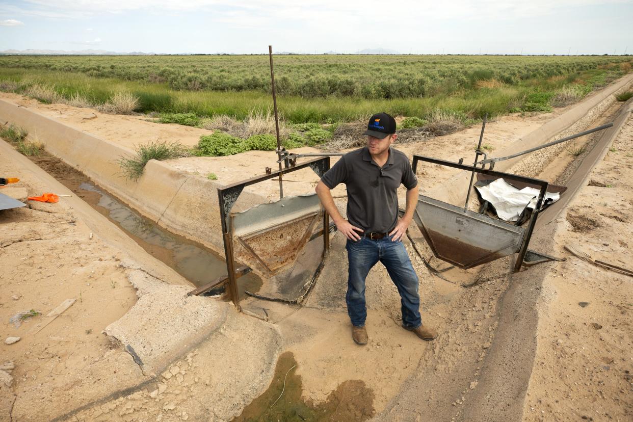 Will Thelander, a farmer with Tempe Farming Company, stands at a junction of two irrigation ditches at the farm outside of Casa Grande on August 13, 2021. The declaration of a water shortage on the Colorado River will cut the amount of water that Pinal County farmers receive from the Central Arizona Project Canal in 2022.