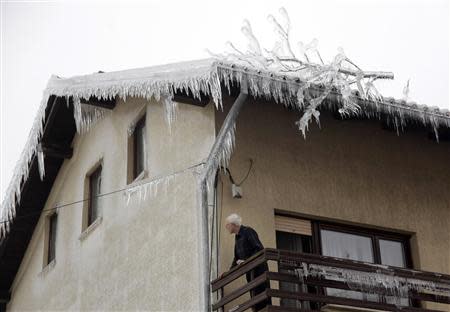 A man observes his ice-covered neighborhood in Pivka February 4, 2014. REUTERS/Srdjan Zivulovic