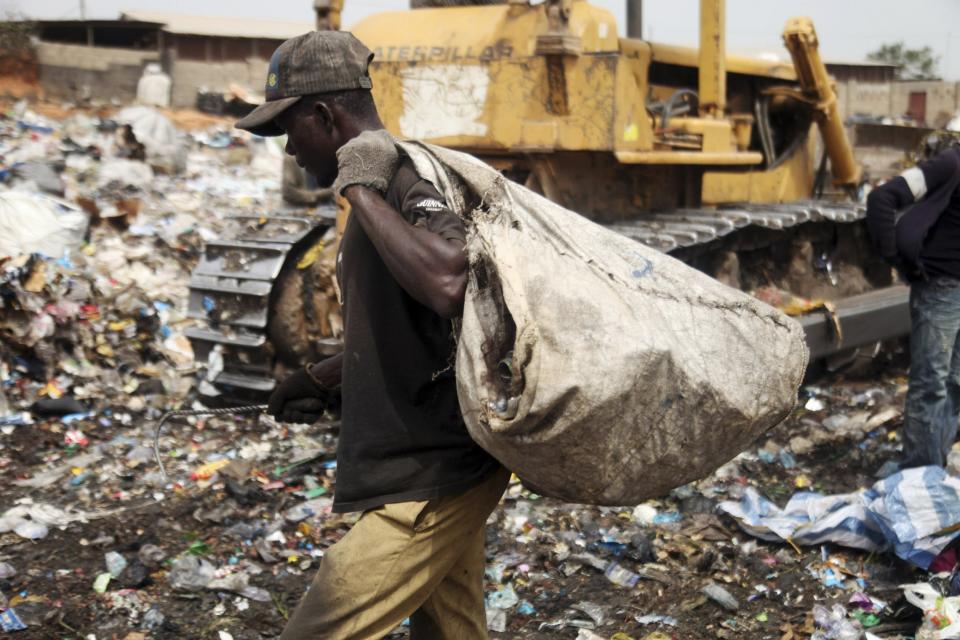 A scavenger picks up trash for recycling at the Olusosun dump site in Nigeria's commercial capital Lagos in this March 23, 2012 file photo. One thing Nigeria's megacity of Lagos, one of the world's largest, generates in abundance is trash. Now it plans to turn that rubbish into electricity which the city desperately lacks. Ola Oresanya, managing director of the Lagos Waste Management Authority (LAWMA) aims to complete the project in around five years, by which time it will have a 25 megawatt (mw) capacity, he said. That is only 1 percent of the 2,000 - 3,000 mw that he estimates Lagosians demand, but it is a start. To match story NIGERIA-RUBBISH/ELECTRICITY/ REUTERS/Akintunde Akinleye/Files (NIGERIA - Tags: ENERGY SOCIETY ENVIRONMENT)