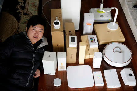 Pan Weida, 31, poses for a picture at his house, displaying some of his 78 Xiaomi devices in Shanghai, China February 10, 2018. REUTERS/Aly Song