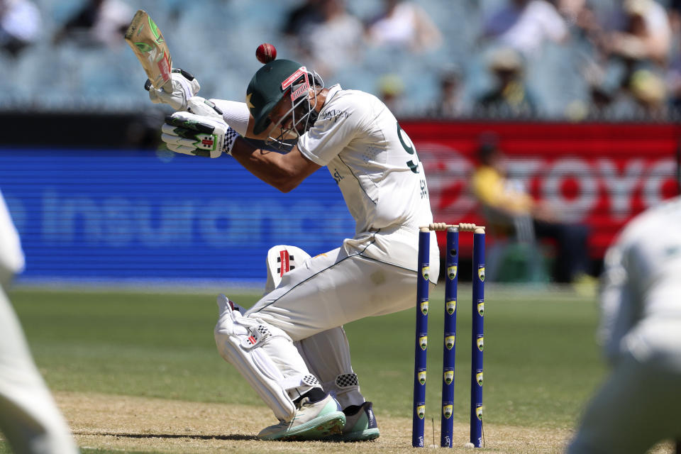 Pakistan's Shan Masood is hit in the head by a delivery from Australia's Josh Hazlewood during the second day of their cricket test match in Melbourne, Wednesday, Dec. 27, 2023. (AP Photo/Asanka Brendon Ratnayake)