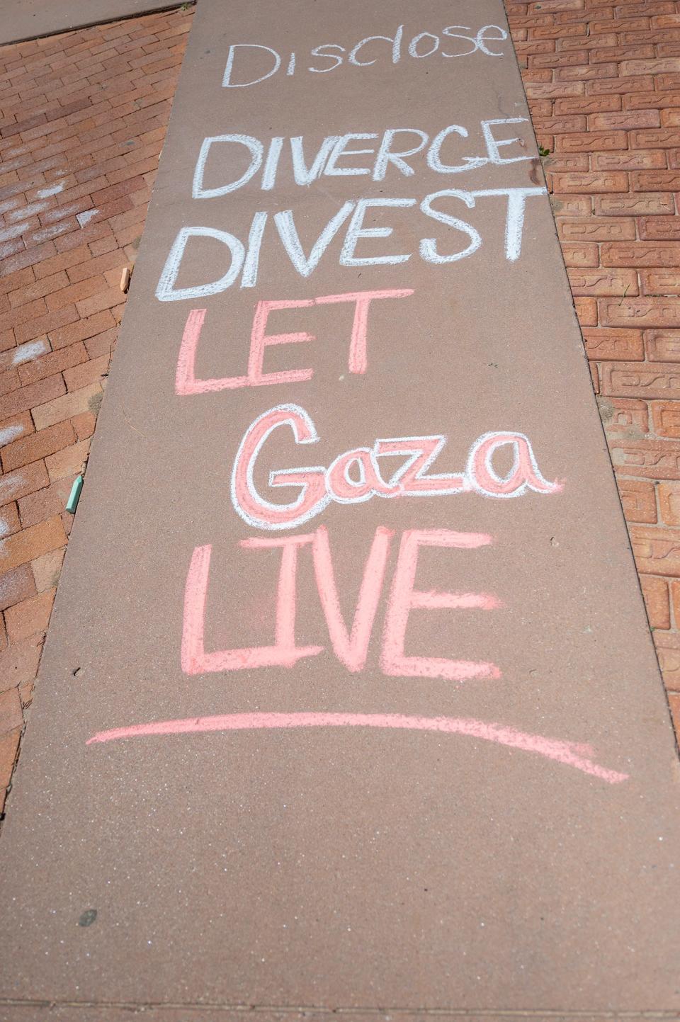 Pro-Palestinian activists put down chalk art during a rally on the campus of Colorado State University Pueblo on Tuesday, April 30, 2024.