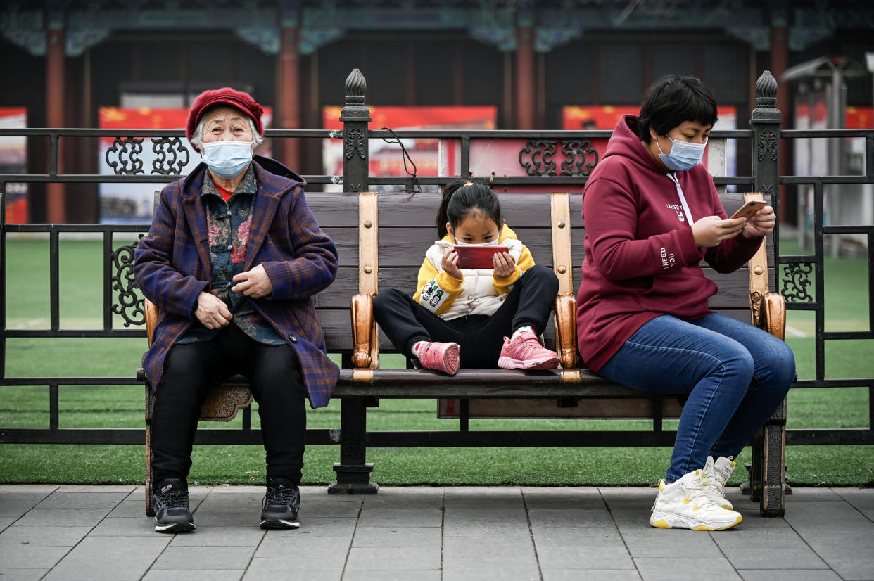 A girl uses a mobile phone in Beijing on March 4, 2021.  (Wang Zhao  / AFP via Getty Images)