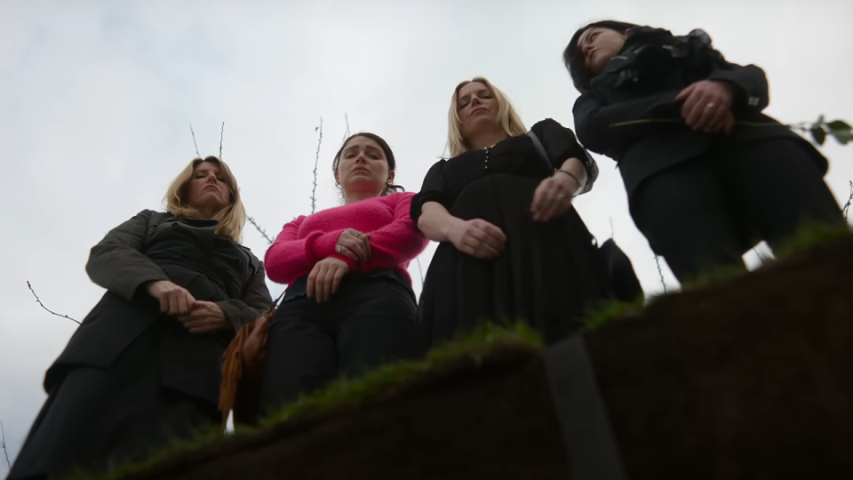 The main stars of Bad Sisters standing over a grave.